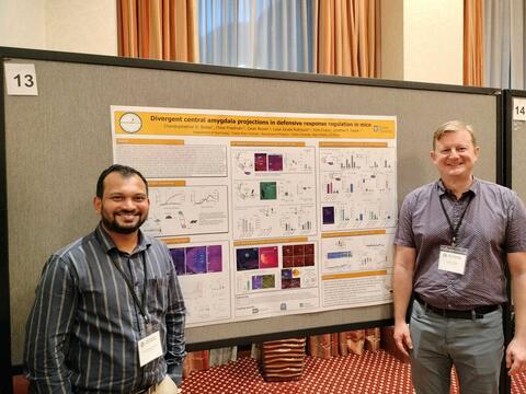 Dr. Fadok and Dr. Borkar stand in front of Dr. Borkar's poster at the Pavlovian society conference.