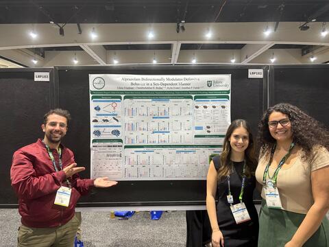 Jose, Chloe, and Maria stand next to Jose's Poster at SfN